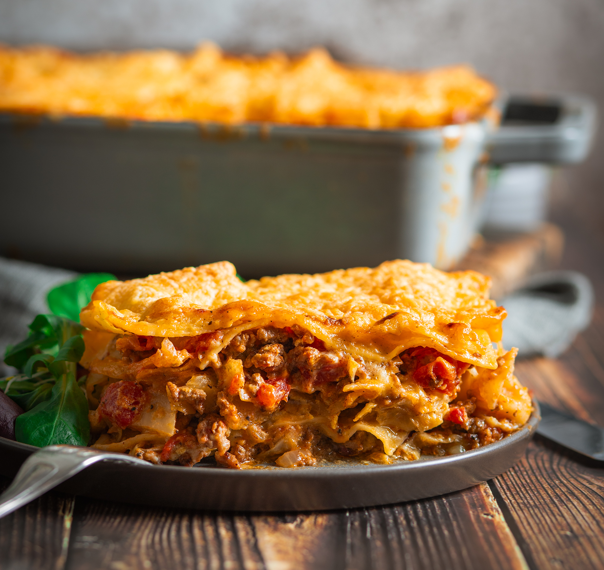 Lasagne mit Weißkohl auf dunklem Holztisch