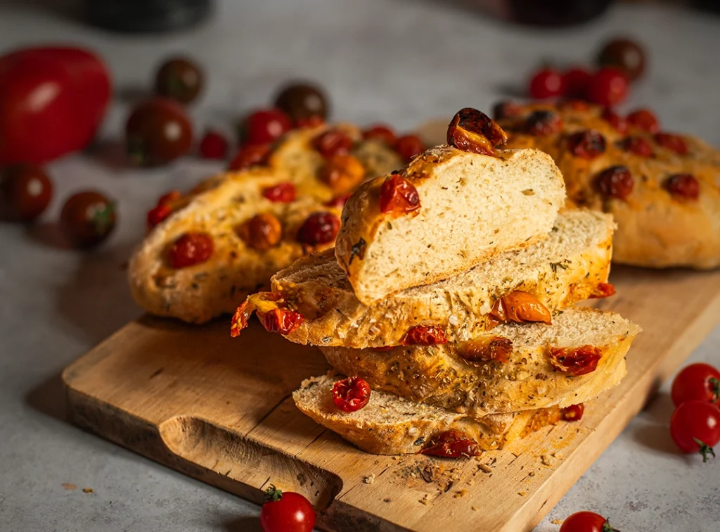 Tomaten-Focaccia angeschnitten auf Holzbrett