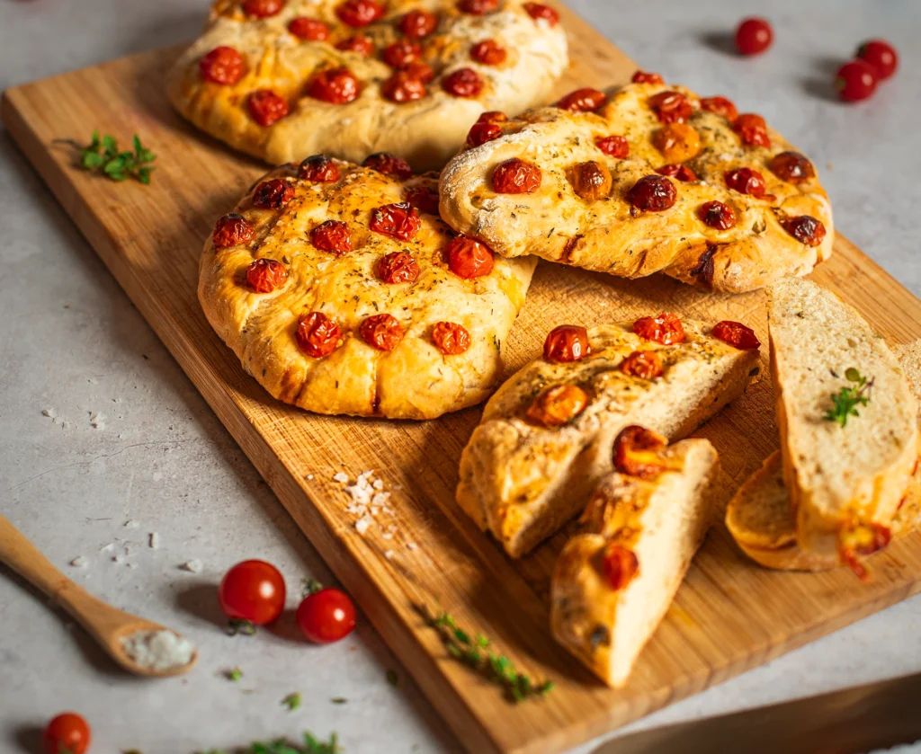 Mehrere Tomaten-Focaccia Fladen auf Holzbrett