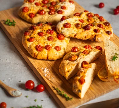 Mehrere Tomaten-Focaccia Fladen auf Holzbrett