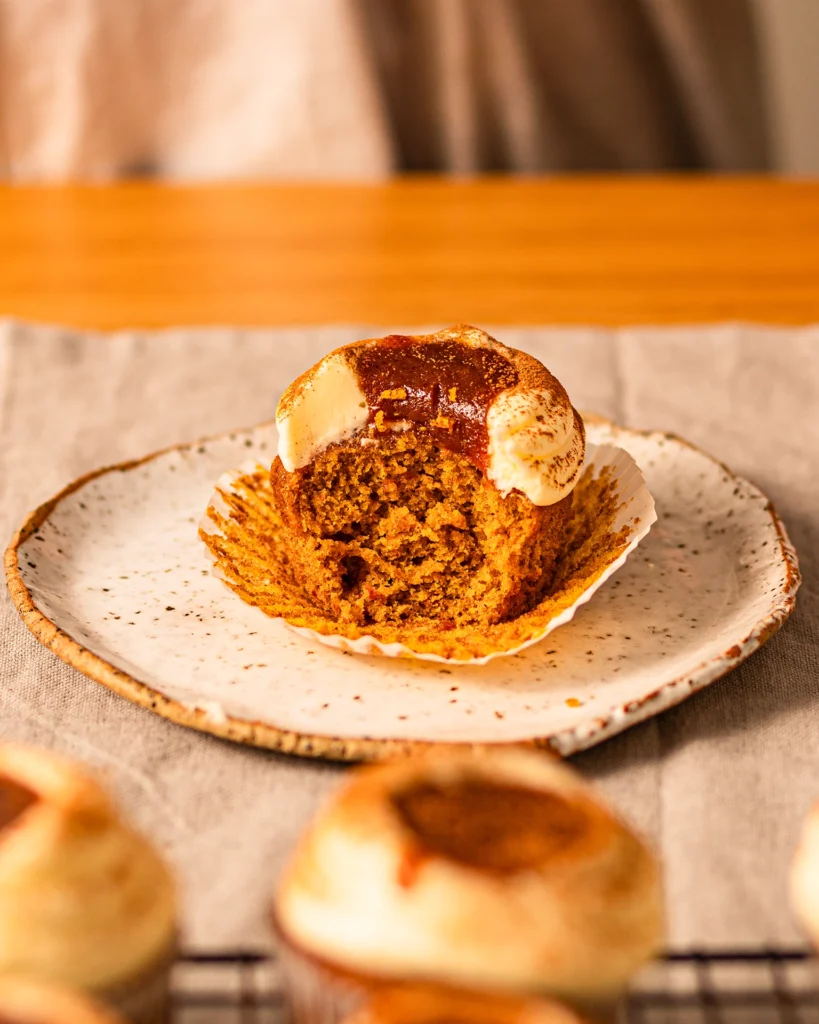 Fluffiger Kürbismuffin angestochen auf Teller mit Frosting