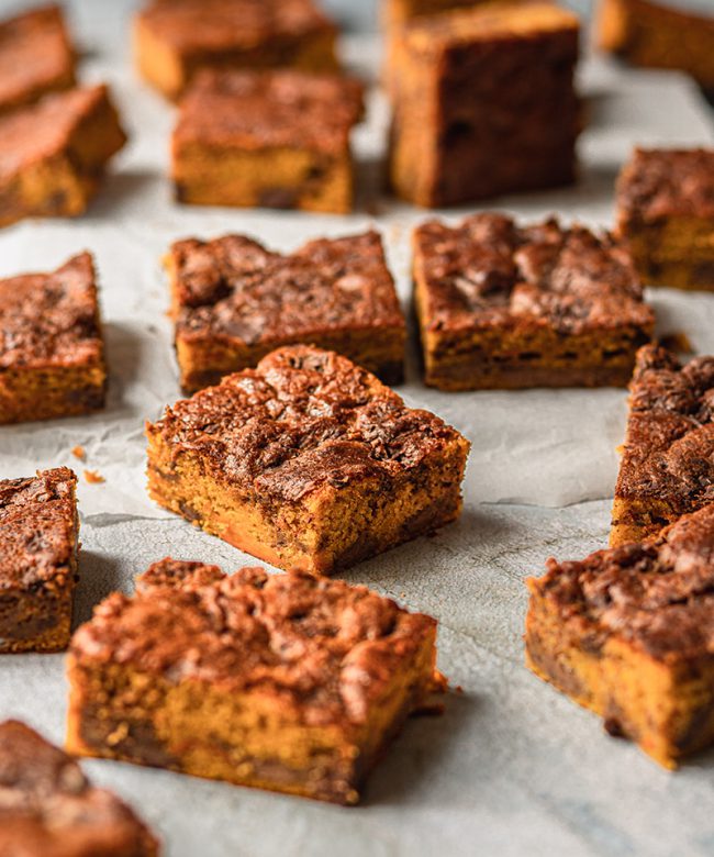 Saftige Kürbis-Brownie Stücken auf Backpapier