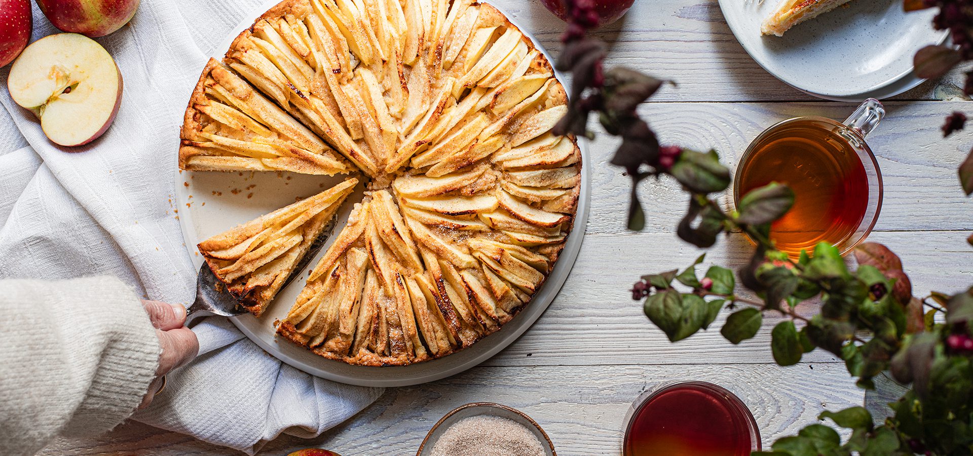 Apfel-Marzipan-Kuchen auf hellem Holztisch in herbstlichem Setting