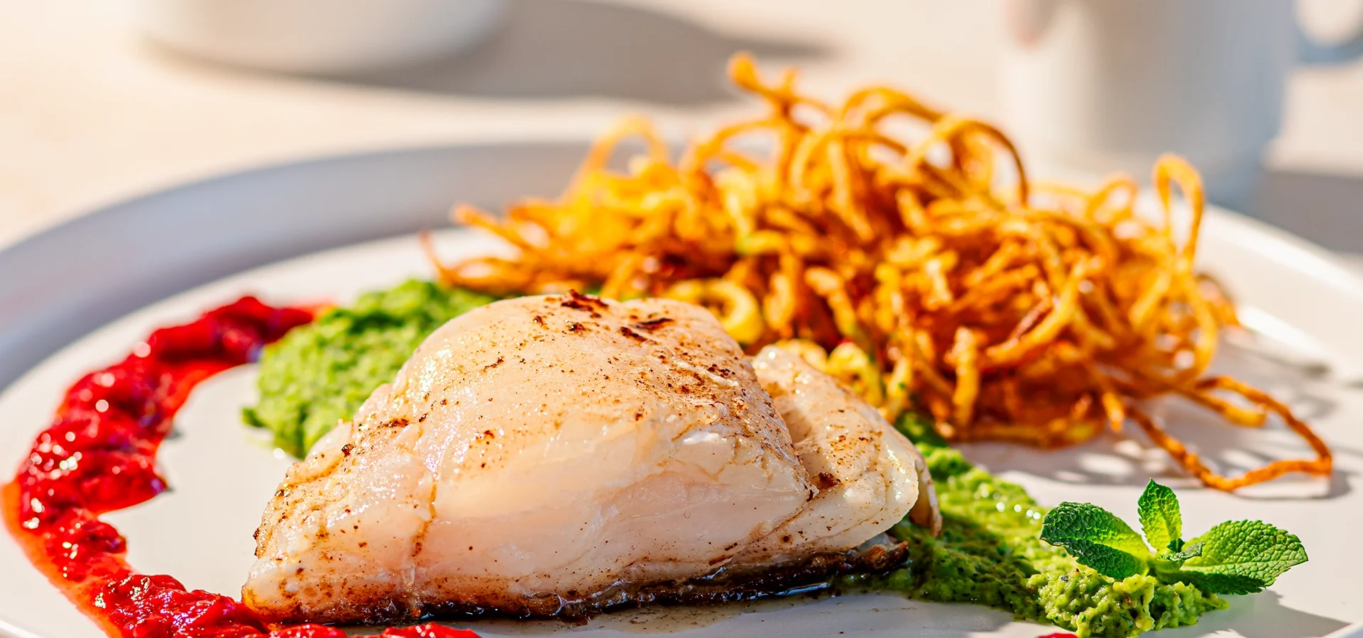 Kabeljau mit Erbsenpüree, Erdbeer-Chili-Sauce und Kartoffelstroh